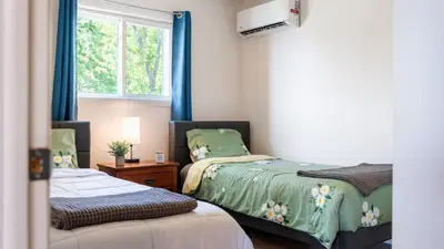 a bedroom with two beds with blue curtains and a window at The Lake Life by AvantStay Lakefront View Hot Tub in Arrowhead Lake