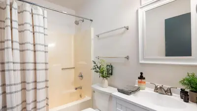 a white bathroom with a sink and a mirror at The Lake Life by AvantStay Lakefront View Hot Tub in Arrowhead Lake