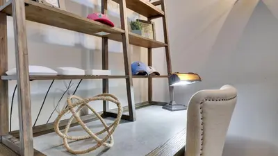 a room with a shelf with a chair and a lamp at The Nest at Pinecrest by AvantStay Spacious Deck Game Room Fire Pit in Pocono Pines