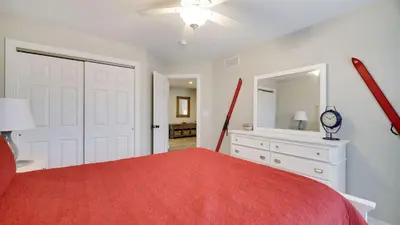 a bedroom with a red bed and a mirror at The Nest at Pinecrest by AvantStay Spacious Deck Game Room Fire Pit in Pocono Pines