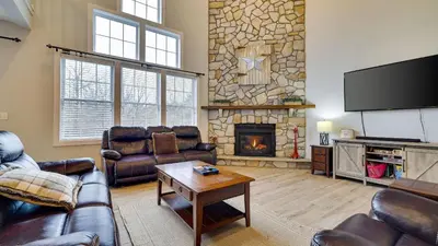 a living room with leather furniture and a stone fireplace at The Nest at Pinecrest by AvantStay Spacious Deck Game Room Fire Pit in Pocono Pines