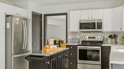 a kitchen with stainless steel appliances and white cabinets at Mountain Mindset by AvantStay Pool Hot Tub Game Room Firepit in Long Pond