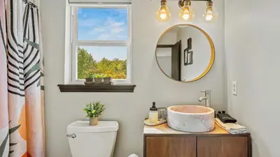 a bathroom with a sink and a mirror at Mountain Mindset by AvantStay Pool Hot Tub Game Room Firepit in Long Pond