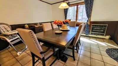 a dining room with a wooden table and chairs at The Wooden Nest by AvantStay Deck Big Yard w Hammocks Fire Pit in Long Pond