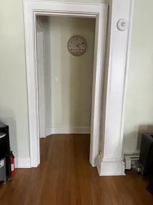 a room with a clock on the wall and a hallway at Modern Queen Room Near EWR in Elizabeth