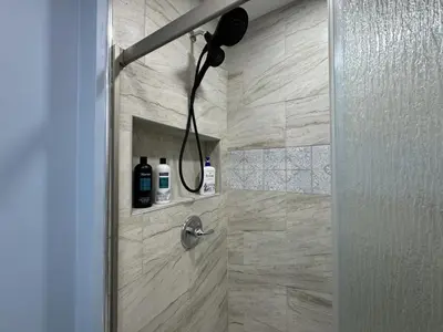 a shower with a shower head in a bathroom at Modern Queen Room Near EWR in Elizabeth