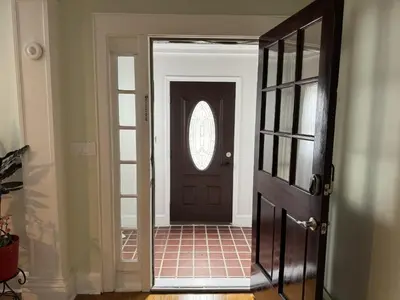 a hallway with a black door and a window at Modern Queen Room Near EWR in Elizabeth