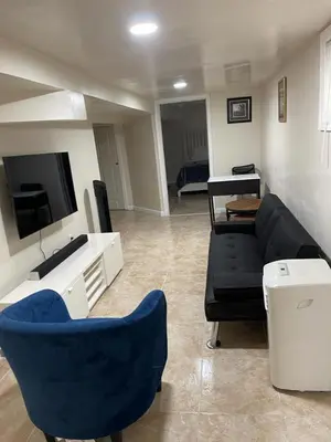 a living room with a black couch and a tv at Z & Z Apartment 2 in Newark