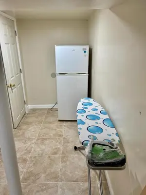 a kitchen with a chair next to a refrigerator at Z & Z Apartment 2 in Newark