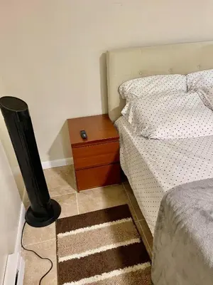 a bedroom with a bed and a wooden night stand at Z & Z Apartment 2 in Newark