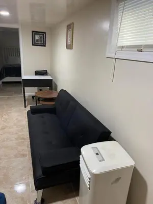 a living room with a black couch and a table at Z & Z Apartment 2 in Newark