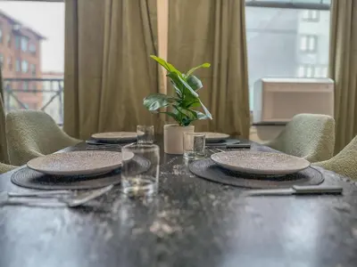 a table with plates and glasses and a plant on it at Sage Stay by the Train, We Pay Half Your Parking, 2 Queen Beds plus Sleeps 6 in Hoboken
