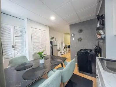 a dining room with a table and chairs and a kitchen at Sage Stay by the Train, We Pay Half Your Parking, 2 Queen Beds plus Sleeps 6 in Hoboken