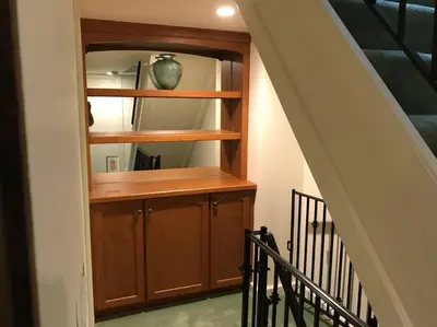 a staircase with a wooden cabinet with a vase in it at Center City Townhome in Quiet Courtyard in Philadelphia