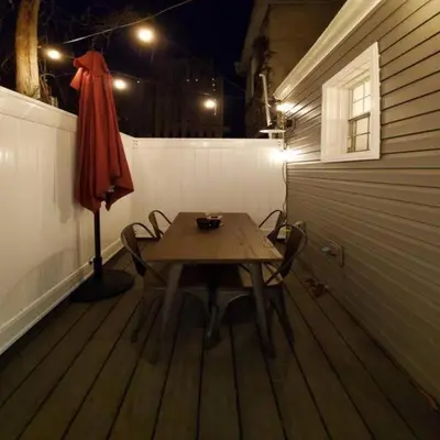 a table with chairs and an umbrella in a room at Fun Fishtown Rowhome - Sleeps 4 in Philadelphia