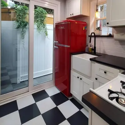 a red refrigerator in a kitchen with a checkered floor at Fun Fishtown Rowhome - Sleeps 4 in Philadelphia