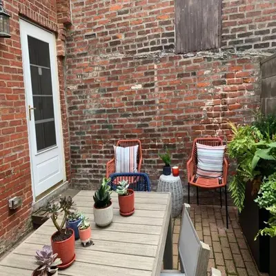a patio with two chairs and a table with plants at Bright & Modern Home with Patio in Philadelphia