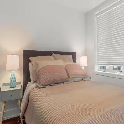 a bedroom with a bed with two lamps and a window at Bright & Modern Home with Patio in Philadelphia