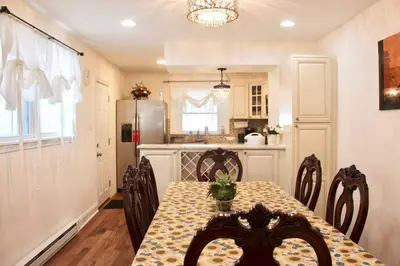 a kitchen with a table with chairs and a refrigerator at Walk to South Philly's Best Restaurants & Bars in Philadelphia