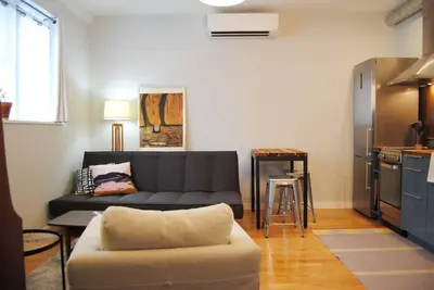 a living room with a couch and a kitchen at Trendy Studio in Prime South Philly Neighborhood in Philadelphia