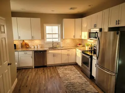 a kitchen with white cabinets and a stainless steel refrigerator at The loft at Park Place - 3rd floor walk up King and Queen beds fast WIFI and free coffee in Wilmington
