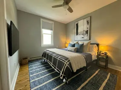 a bedroom with a bed and a flat screen tv at Modern cozy unit with King Bed in Wilmington