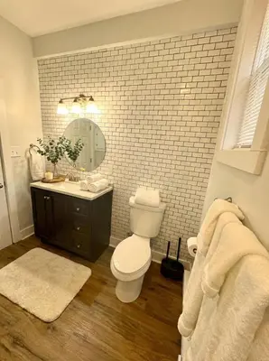a bathroom with a toilet and a sink and a mirror at Modern cozy unit with King Bed in Wilmington