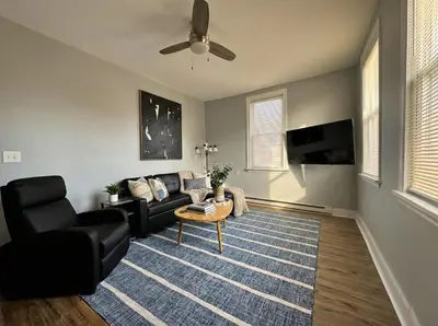 a living room with a couch and a ceiling fan at Modern cozy unit with King Bed in Wilmington