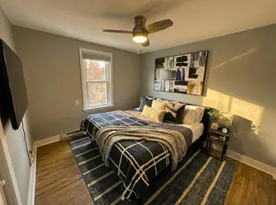 a bedroom with a bed and a ceiling fan at Modern Cozy walk up with King Bed in Wilmington