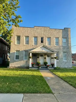 a brick building with flowers in front of it at Modern Cozy walk up with King Bed in Wilmington
