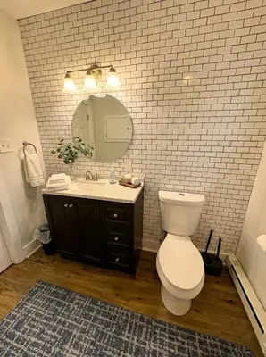 a bathroom with a toilet and a sink and a mirror at Modern Cozy walk up with King Bed in Wilmington