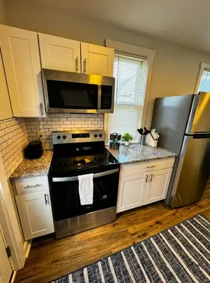a kitchen with a stove and a stainless steel refrigerator at Modern Cozy walk up with King Bed in Wilmington