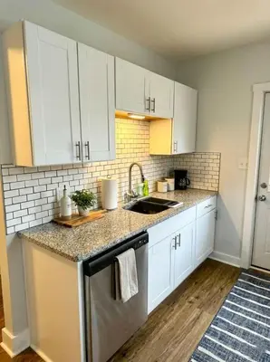 a kitchen with white cabinets and a sink at Modern Cozy walk up with King Bed in Wilmington
