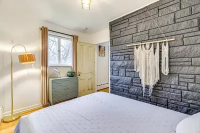 a bedroom with a brick wall and a bed at Game Room and Hot Tub! Cresco Family Home in Cresco