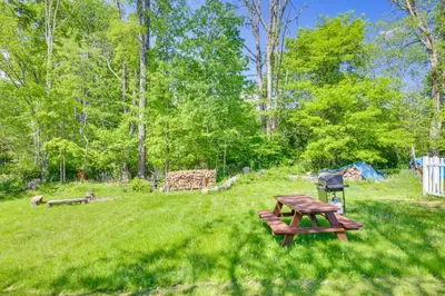 a picnic table and a grill in a field at Game Room and Hot Tub! Cresco Family Home in Cresco