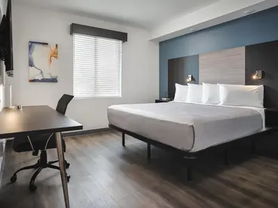 a bedroom with a large bed and a desk at stayAPT Suites Harrisburg-Hershey in Harrisburg