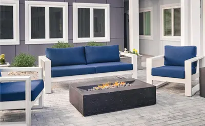 a patio with two blue couches and a fire pit at stayAPT Suites Harrisburg-Hershey in Harrisburg