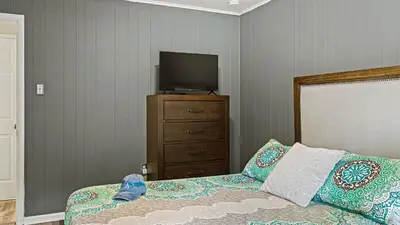 a bedroom with a bed and a television on a dresser at Frolic on Fern by AvantStay Enclosed Deck w Forest Views Bar in Blakeslee