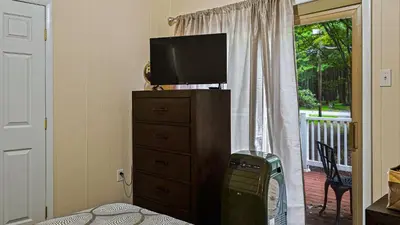 a television on top of a dresser in a room at Frolic on Fern by AvantStay Enclosed Deck w Forest Views Bar in Blakeslee