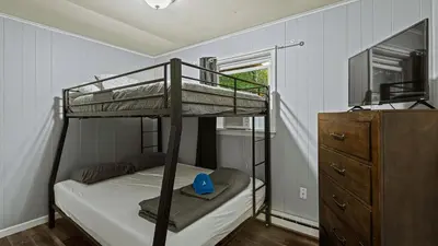 a bedroom with a bunk bed and a dresser at Frolic on Fern by AvantStay Enclosed Deck w Forest Views Bar in Blakeslee