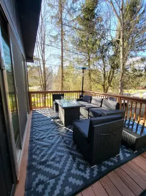 a patio with couches and a table on a deck at Lake Luxe in Lake Ariel