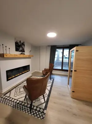 a living room with a fireplace and a table and chairs at Lake Luxe in Lake Ariel