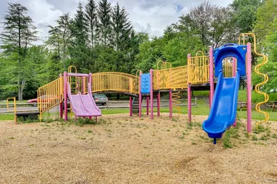 a row of colorful playground equipment in a park at Tobyhanna Home with Fire Pit 1 Mi to Lake Carobeth! in Tobyhanna