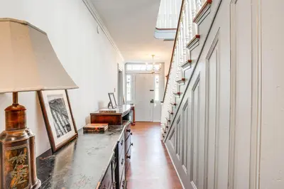 a hallway with white walls and a table with a lamp at Tranquil and Historic Estate Near Valley Forge in Eagleville