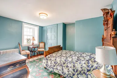 a bedroom with blue walls and a bed and a desk at Tranquil and Historic Estate Near Valley Forge in Eagleville