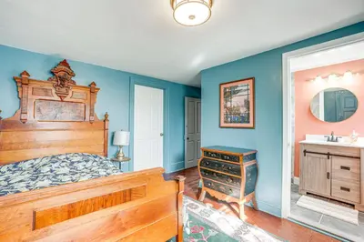 a bedroom with a wooden bed and a sink at Tranquil and Historic Estate Near Valley Forge in Eagleville