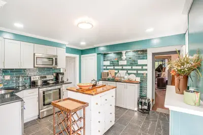 a kitchen with white cabinets and blue walls at Tranquil and Historic Estate Near Valley Forge in Eagleville