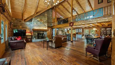 a large living room with a large stone fireplace at Bigwood Cabin Near Camelback Skiing Hot Tub Game Room Firepit Yard in Long Pond