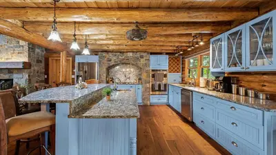 a kitchen with blue cabinets and a large island at Bigwood Cabin Near Camelback Skiing Hot Tub Game Room Firepit Yard in Long Pond