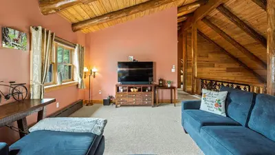 a living room with a blue couch and a tv at Bigwood Cabin Near Camelback Skiing Hot Tub Game Room Firepit Yard in Long Pond